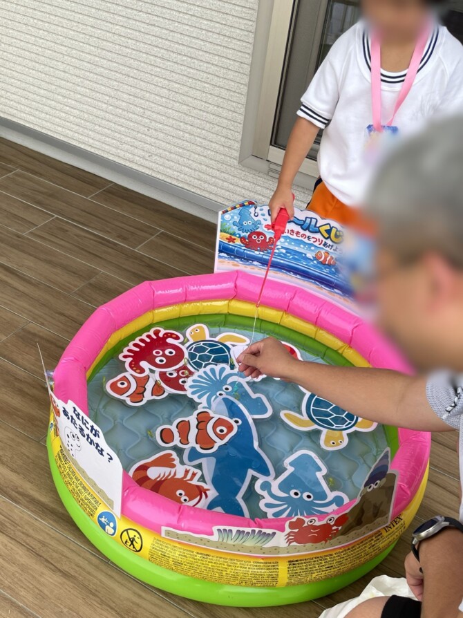 プールで釣り遊びをしている父娘