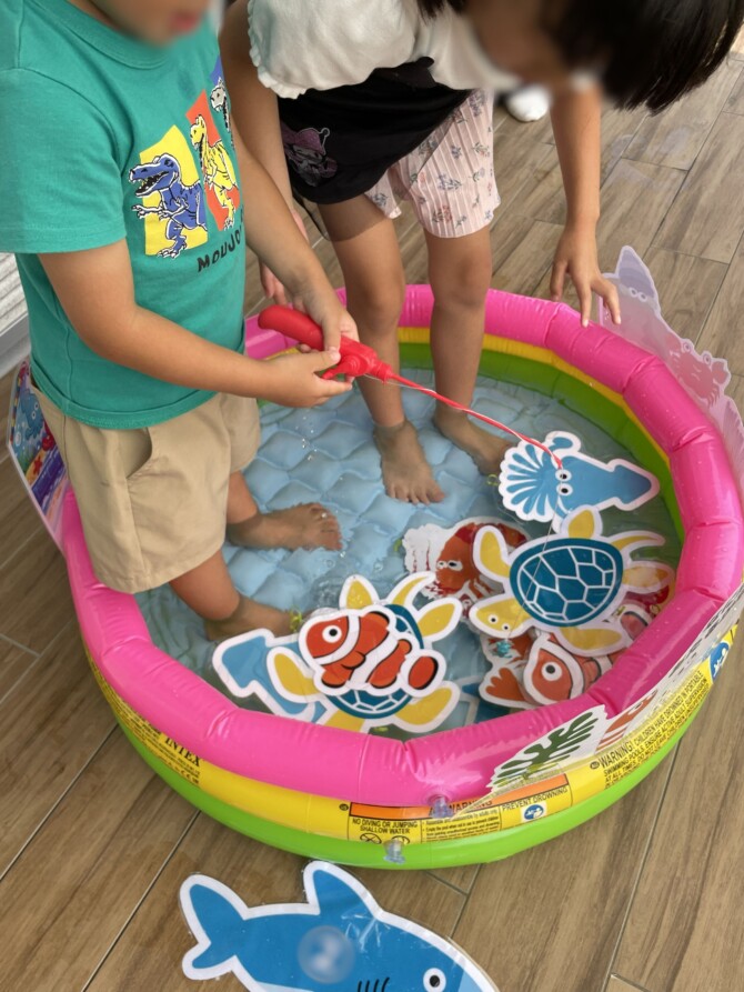 プールの中のくじを釣っている男の子