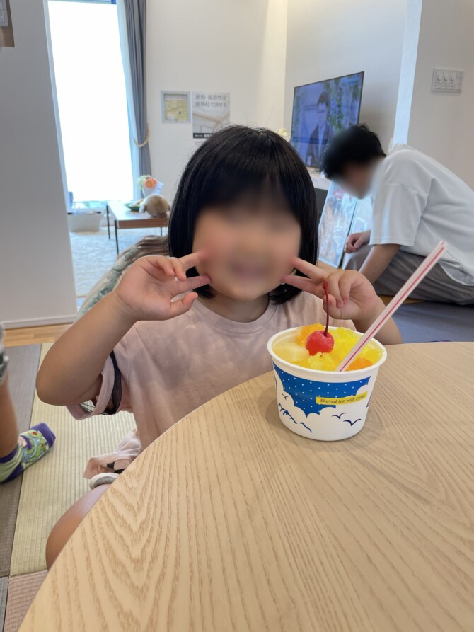 かき氷を食べてピースをしている女の子