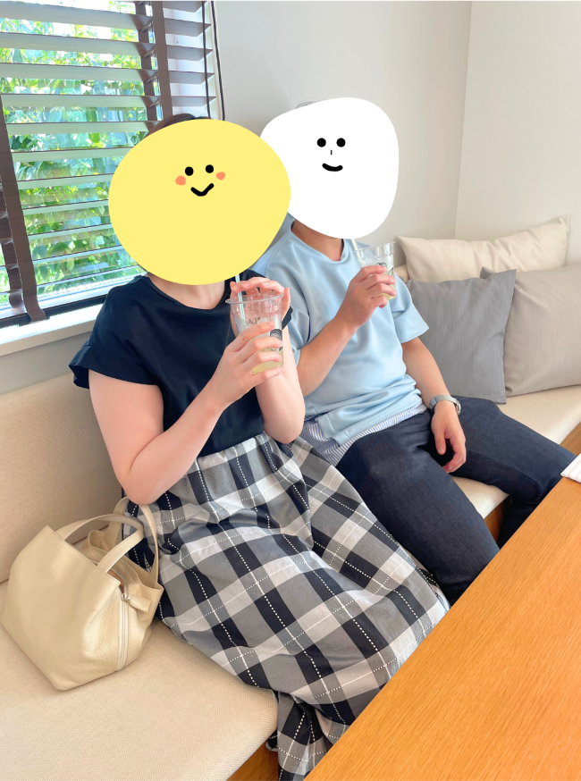 ソファでジュースを飲んでくつろいでいる夫婦