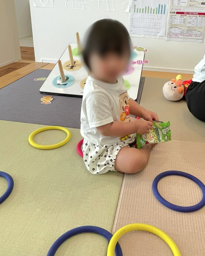畳コーナーでお菓子を食べている女児