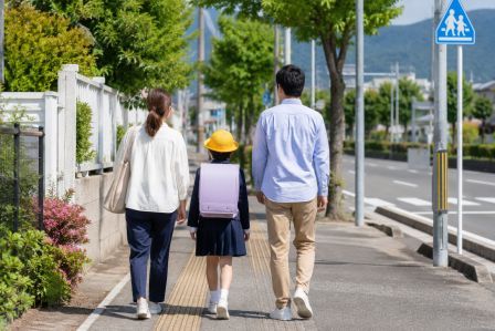 歩道が整備された通学路を歩く小学生と保護者