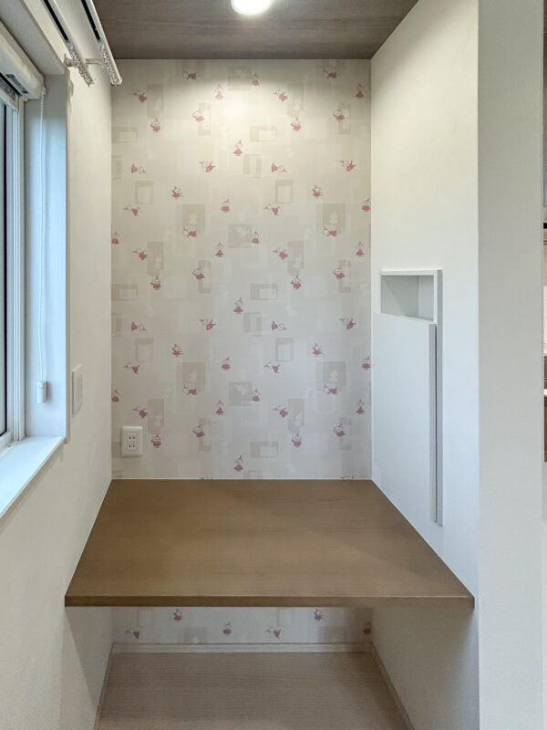 可愛らしいアクセントクロスに、扉付きニッチ収納を備えたカウンタースペース