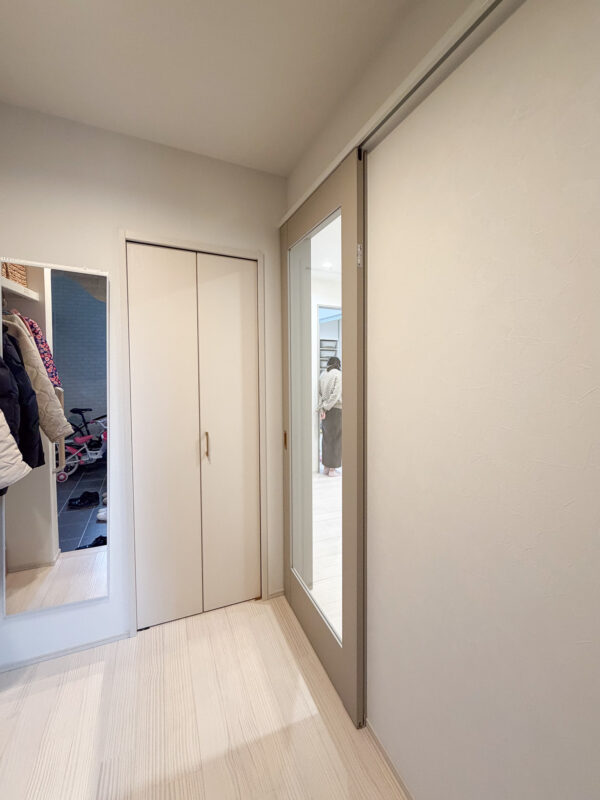 やわらかな光が玄関ホールまで差し込む大きなガラス面のリビングドア