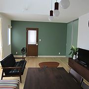 グリーンカラーのクロスにリビングドアがとても映えます。また、ソファやダイニングテーブルなどの家具にもこだわりを感じます。