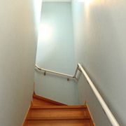 無垢のフローリングなので階段はすべり止め防止にも。玄関からの延長で、壁紙は薄いブルーです。