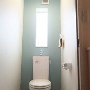 11階トイレはタンクレス風のトイレを採用しました。トイレ、手洗器、手摺は白で統一していますが、一部のクロスの色を変更しています。敢えて濃いグレーを設ける事で白い手洗器とお客様がご自分で購入されたペーパーホルダーとタオルリングが映えるようになってます。2階トイレは明るいブルーを採用しました。これもまたトイレの白さとマッチして、清潔感がありながらもちょっとした遊びを含んだ空間に仕上がりました。