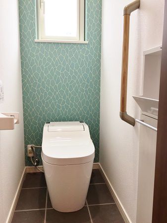 トイレはグレーのタイルやブルーのアクセントクロスで、シックで印象的な空間になりました。