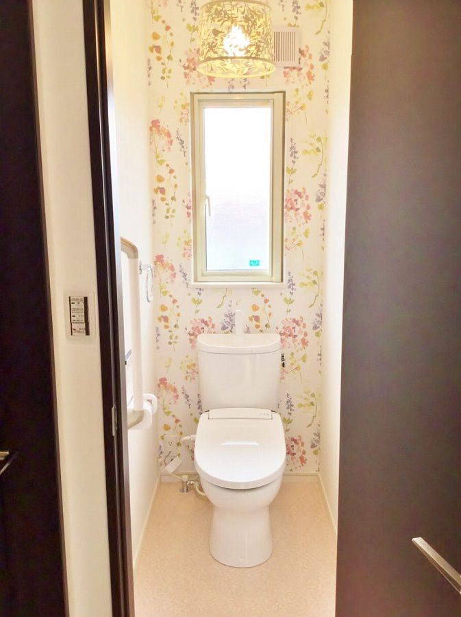 2階のトイレは一風変わってとてもかわいい空間に。照明も背景の花柄とマッチしています。