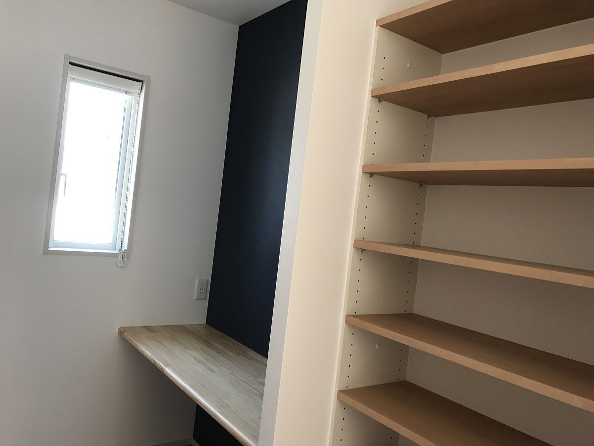 戸建てに住むなら欲しかったというご主人の書斎スペース
濃紺のクロスを使ってかっこいい空間を作りました。
またカウンター横の本棚スペースは木調の可動棚を使って落ち着いた雰囲気を。