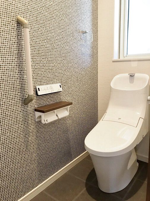 トイレはタイル調のアクセントクロスが印象的な大人の空間に。