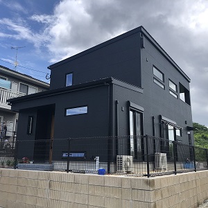 外壁のデザインはアークディンプル（コンクリート打ちっぱなし風）にし、塗装は黒で仕上げました。屋根や窓周りも黒でそろえ、統一感があってモダンなかっこいい外観です。