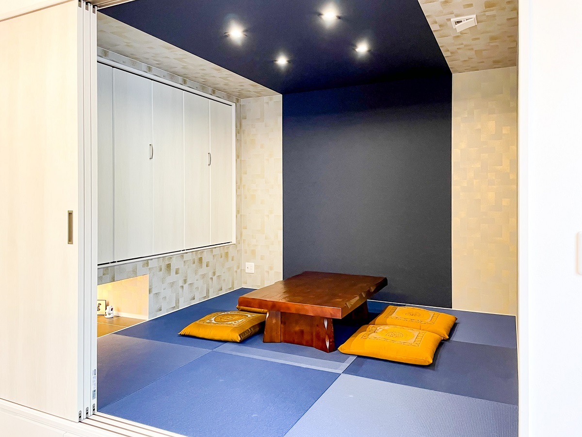 キッチン横の和室は、金色のアクセントが入った壁紙をベースに、藍色のグラデーションが美しいモダンな小上がり和室。和紙畳の藍色と、壁から天井にむかって貼られた藍色の壁紙、収納も床上げしており、飾り物をできるスペースも確保しています。ゲストが泊まる際には、扉を閉めることで個室としても使用することができます。